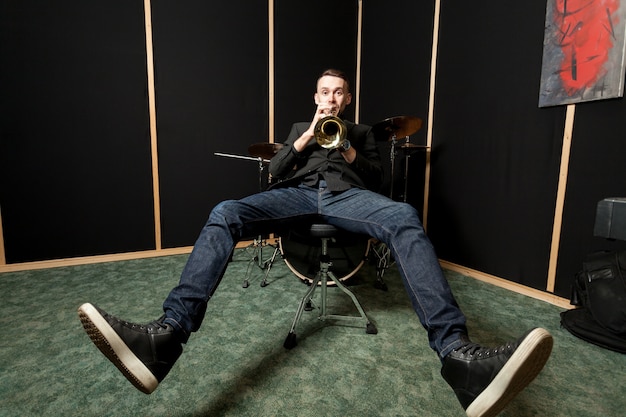 Free photo trumpet player chilling on chair