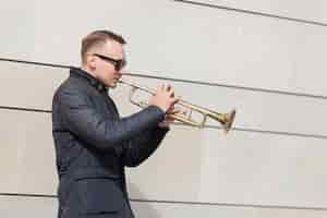 Free photo trumpet player playing outdoors