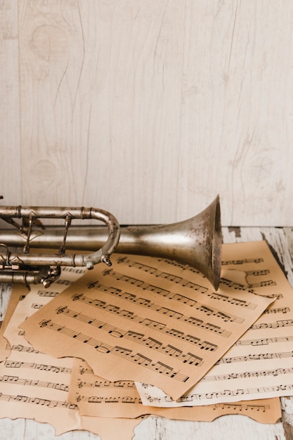 Free photo trumpet and sheet music near wooden wall