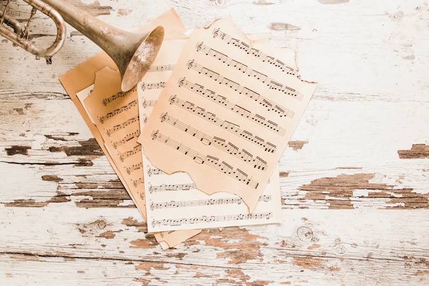 Free Photo trumpet and sheet music on old table