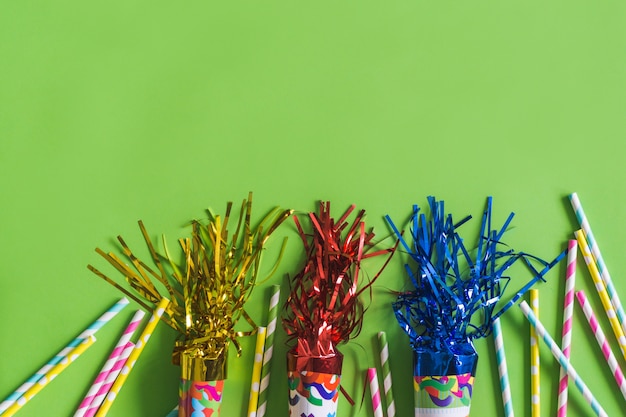 Trumpets with serpentine and colorful sticks on a green table