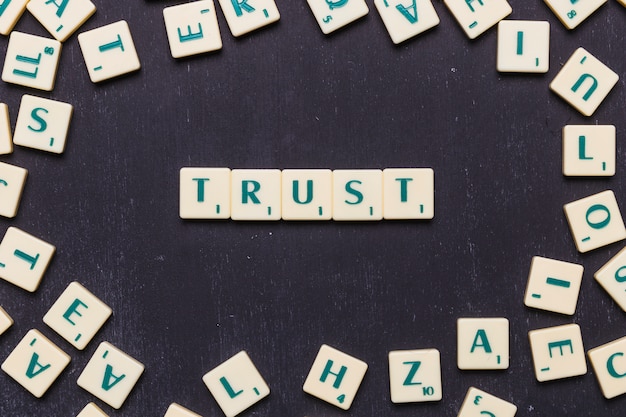 Free Photo trust word arranged on black background surrounded by scrabble letters