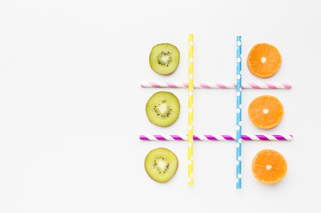 Free photo ttic-tac-toe game with fruits and straws