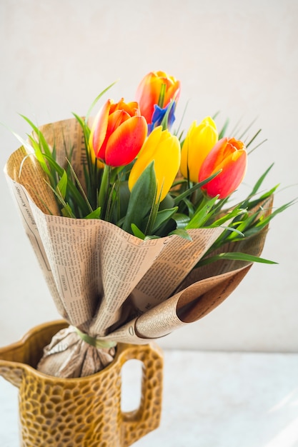 Tulip flowers bouquet in pack paper in jug