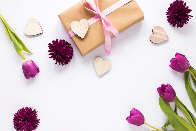 Tulip flowers with gift box and wooden hearts 