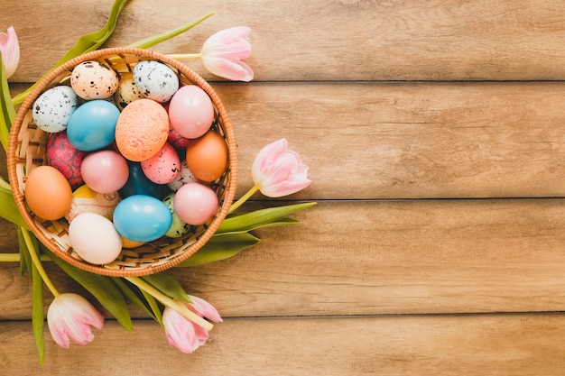 Free photo tulips around bowl with eggs