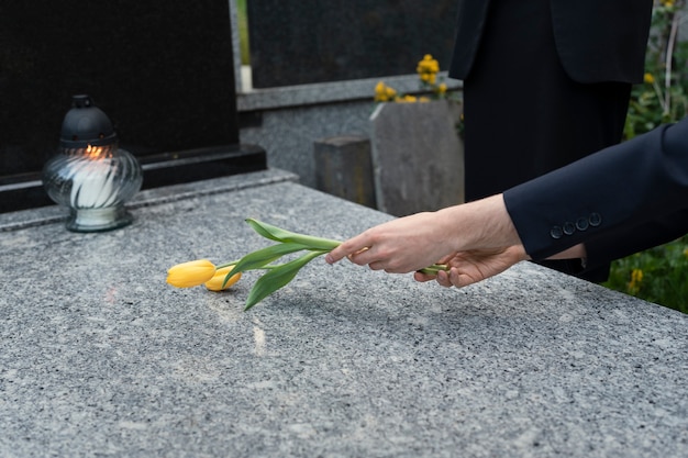 Free photo tulips being brought to a grave at the cemetery