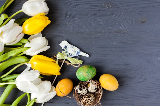 Tulips near quail and colored eggs