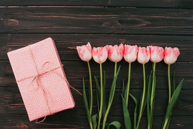 Tulips with gift box on wooden table