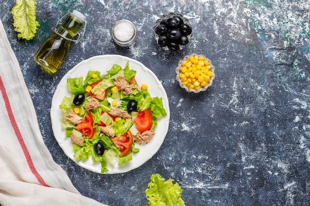 Tuna salad with lettuce,olives,corn,tomatoes,top view