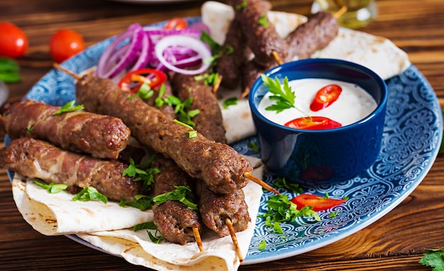 Free photo turkish and arabic traditional ramadan mix kebab plate. kebab adana, chicken, lamb and beef on lavash bread with sauce. top view