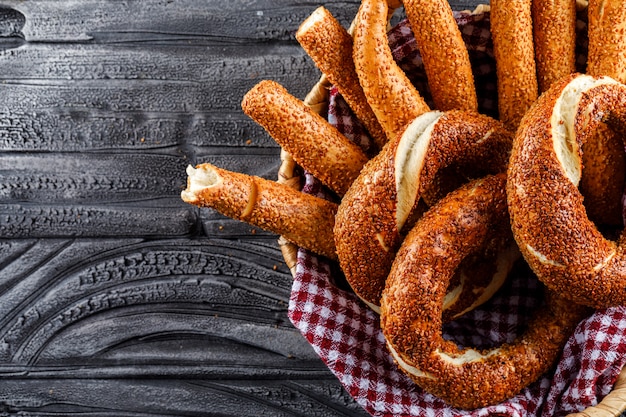 Turkish bagel in a basket top view on a dark wooden surface, space for text