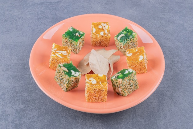 Turkish delight. lokum or rahat lokum on orange plate over grey background.