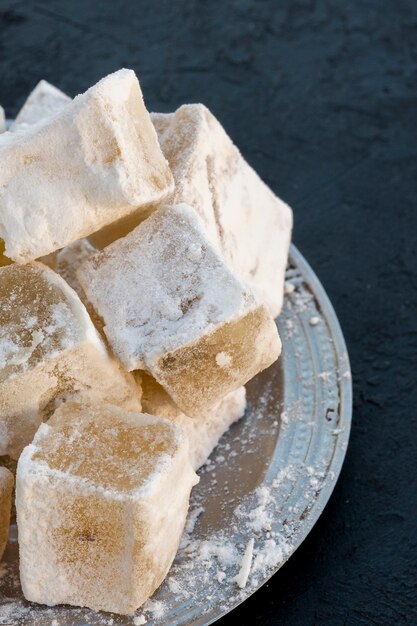 Turkish delight on plate on black table