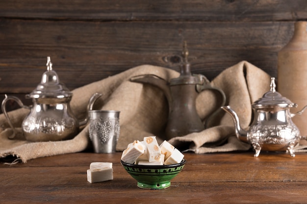 Turkish delight with teapots on wooden table