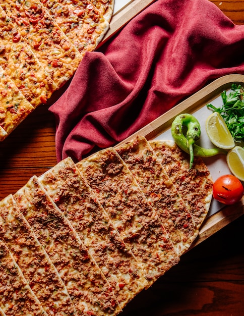 Turkish fast food lahmacun served with lemon and vegetables.