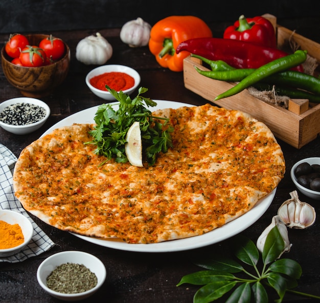 Free Photo turkish lahmajun with stuffed meat, a slice of lemon and herbs