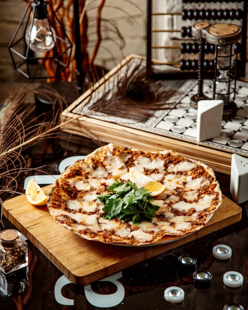 Turkish pizza lahmajun with minced meat bell pepper and cheese with parsley and lemon