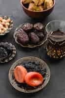 Free photo turkish tea with dates and dried apricot; raisin in an arabian iron plate for ramadan