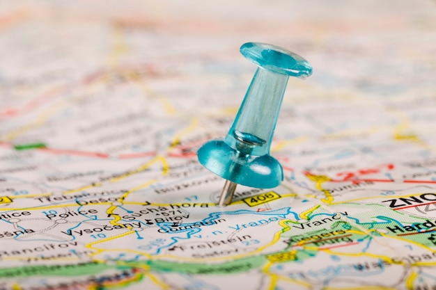 Free photo turquoise colored pushpin stucked in world map