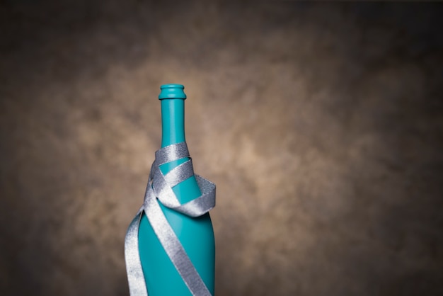 Free photo turquoise decorative bottle wrapped with silver ribbon