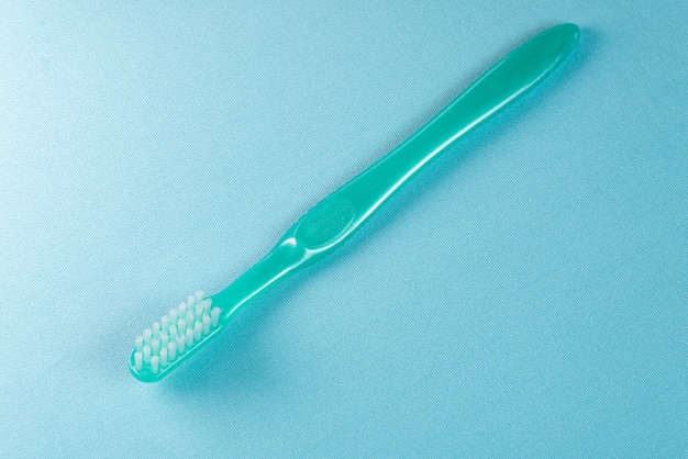 Turquoise toothbrush on the blue surface