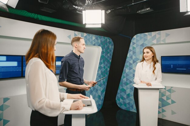 TV game show with two participants answering questions or solving puzzles and host. Smiling women participate in television quiz.