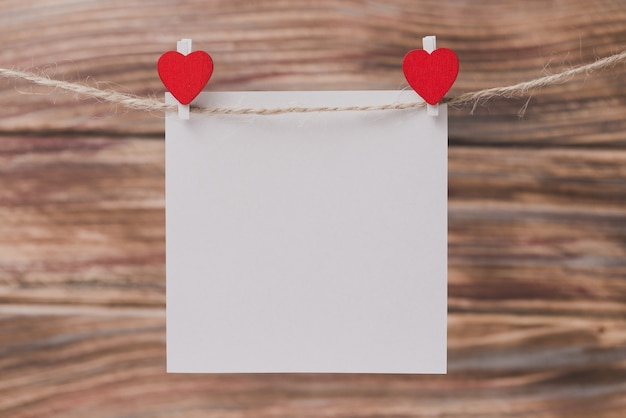 Tweezers with a heart holding a paper