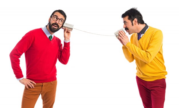 Twin brothers talking through a tin phone