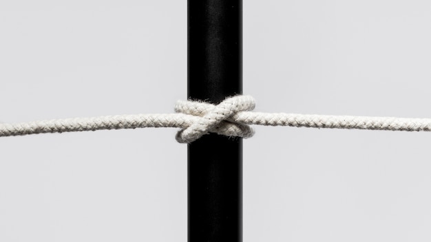 Free Photo twisted cotton rope surrounding a black bar