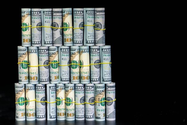 Twisted dollar bills on a black background finance concept background