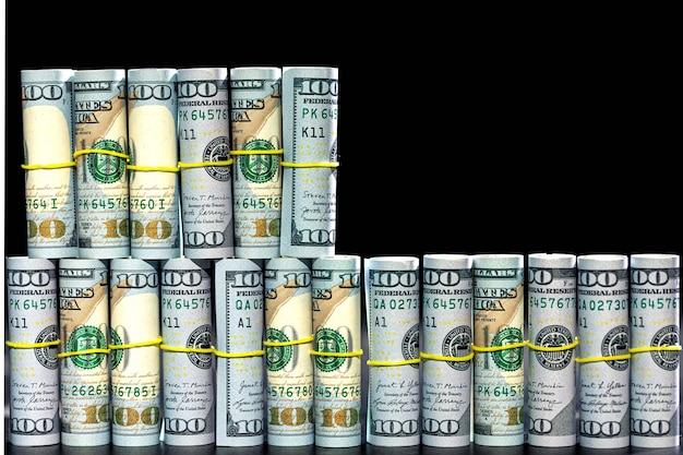 Twisted dollar bills on a black background finance concept background