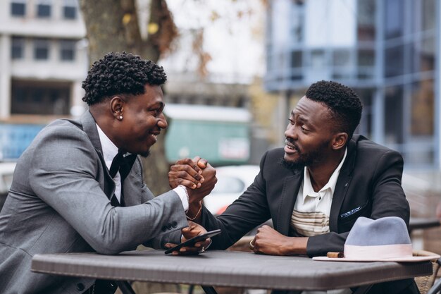 Two african businessman sitting outside cafe