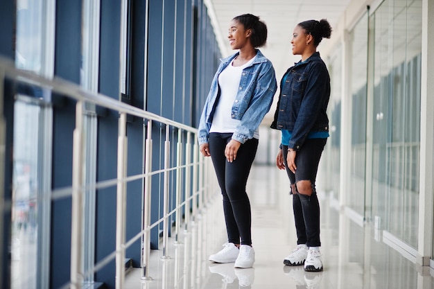 Two african woman friends in jeans jacket posed indoor together