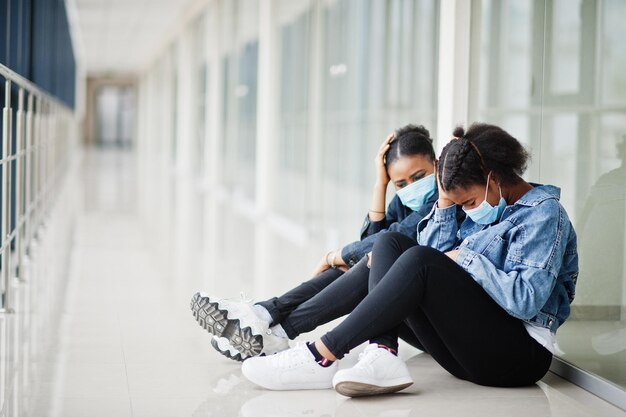 Two african woman friends in jeans jacket wearing protective masks Virus concept health medical