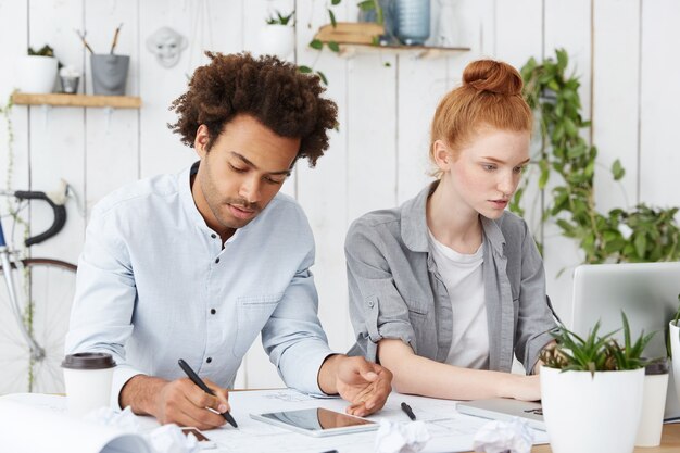 Two architect coworkers working hard, facing deadline