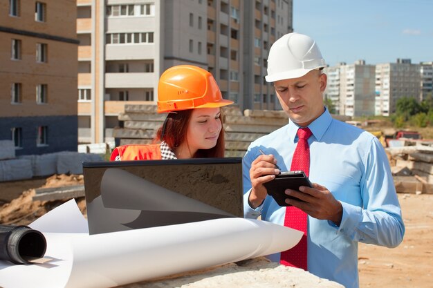 Two architects  in front of building site