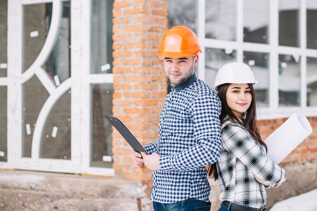 Two architects in front of house