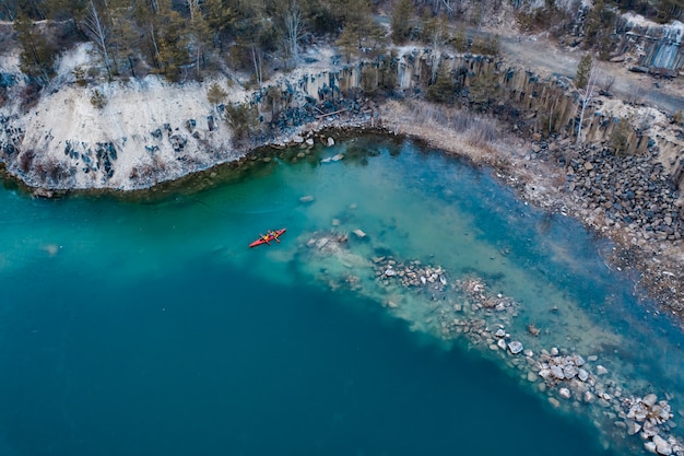 Two athletic man floats on a red boat in river