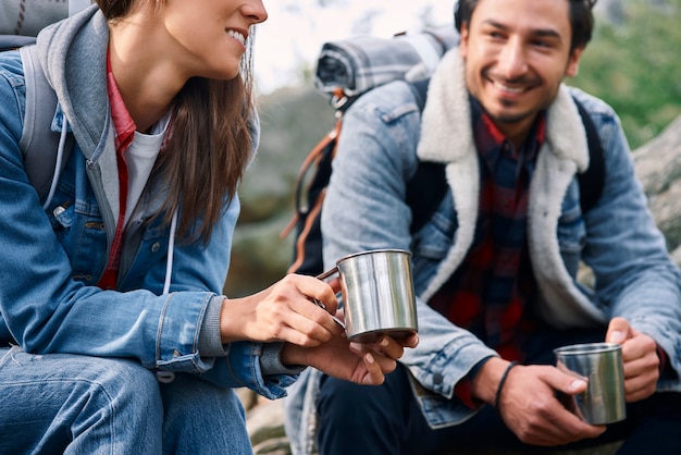 Free photo two backpackers drinking coffee and talking