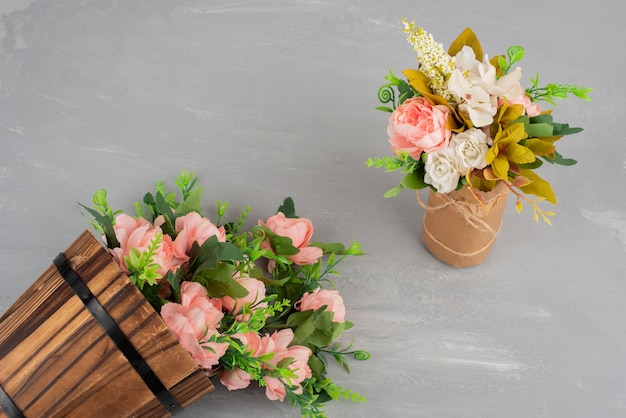 Two beautiful bouquets of flowers on grey surface