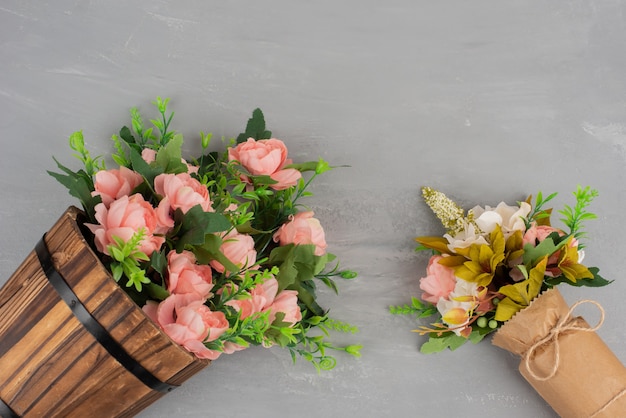 Two beautiful bouquets of flowers on grey surface.