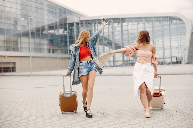 Two beautiful girls standing by the airport