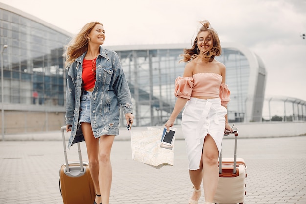 Two beautiful girls standing by the airport