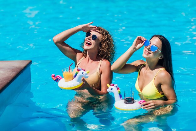 Two beautiful girls in swimsuits in the pool