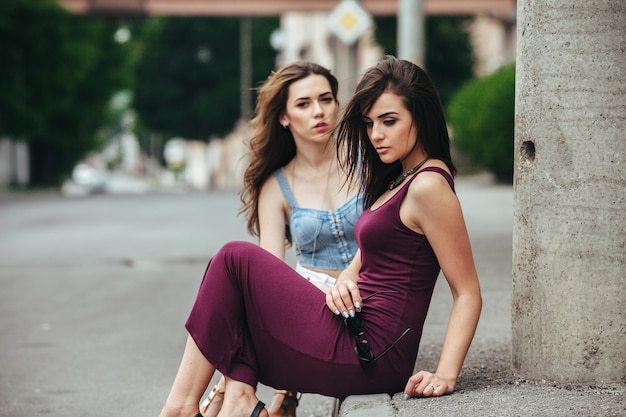 Two beautiful young girls posing on the street