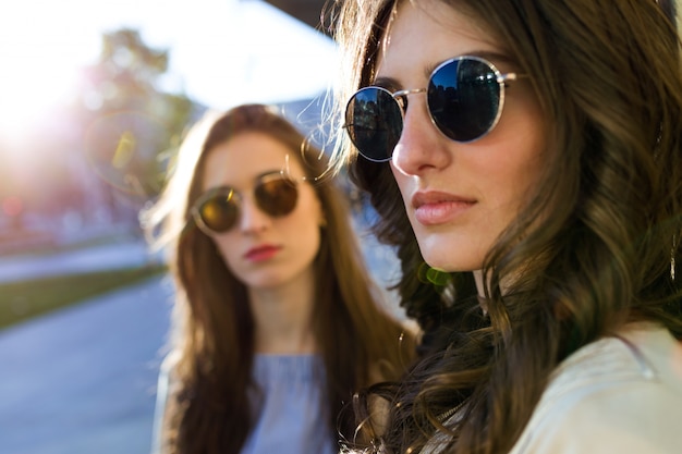 Two beautiful young women posing in the street.