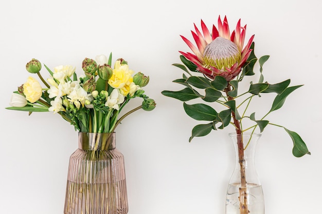 Two bouquets of flowers on a white background in vases