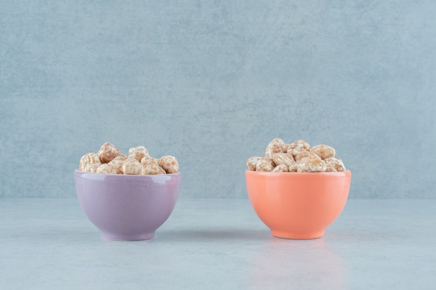 Two bowls full of sweet delicious gingerbread on white surface