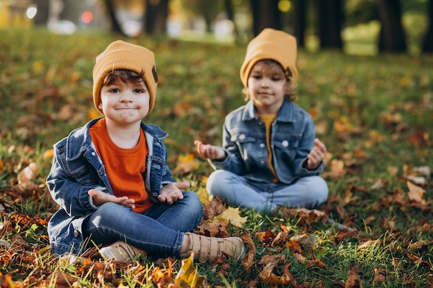 Two boys brothers doing yoga in park